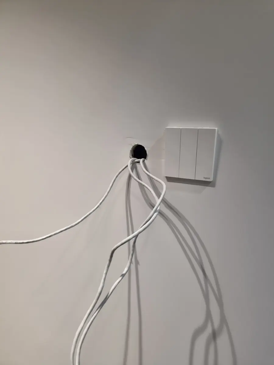 벽 구멍에서 길게 늘어진 흰색 배선들